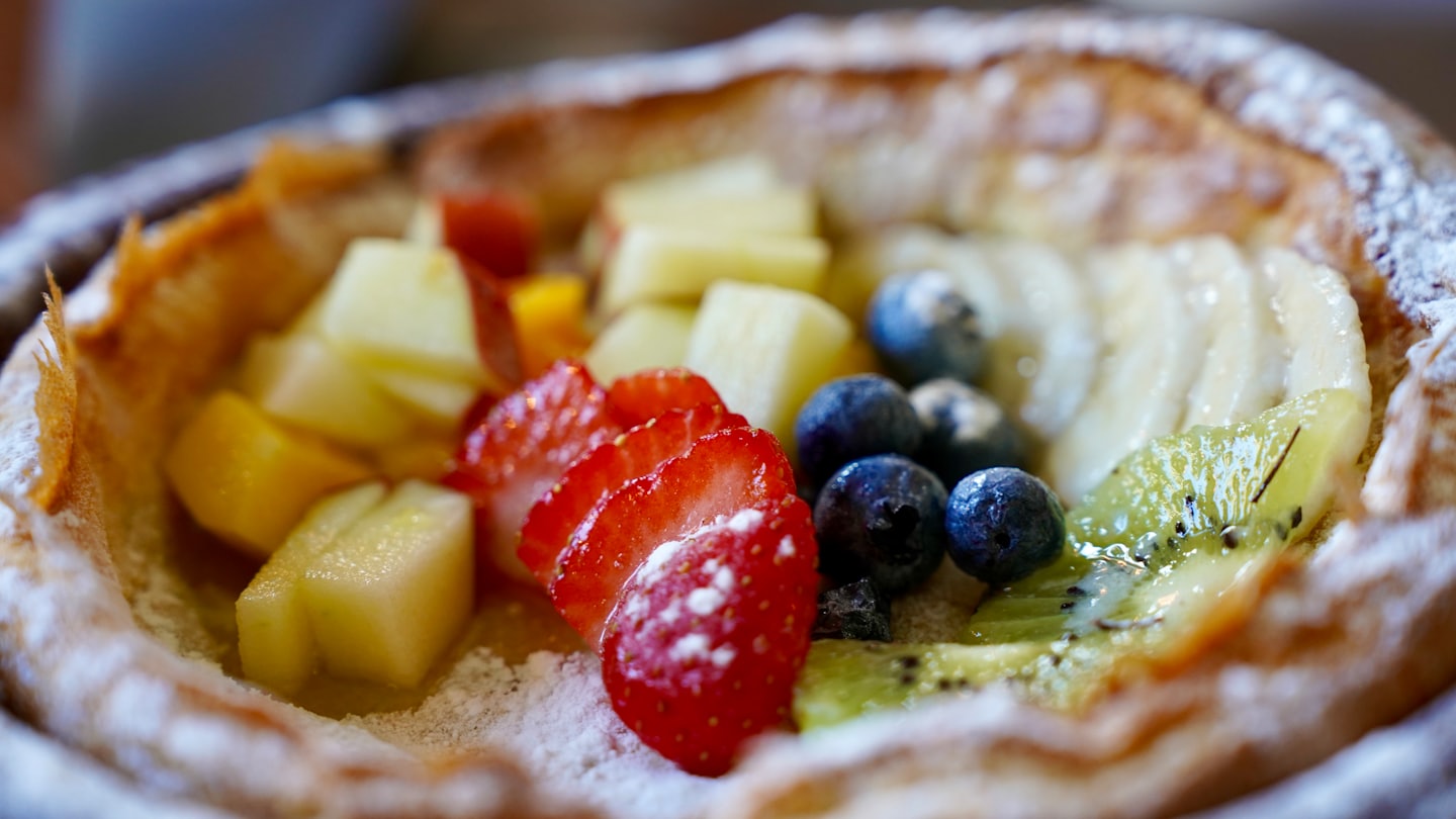 Dutch baby pancake topped with fresh fruit and powdered sugar.