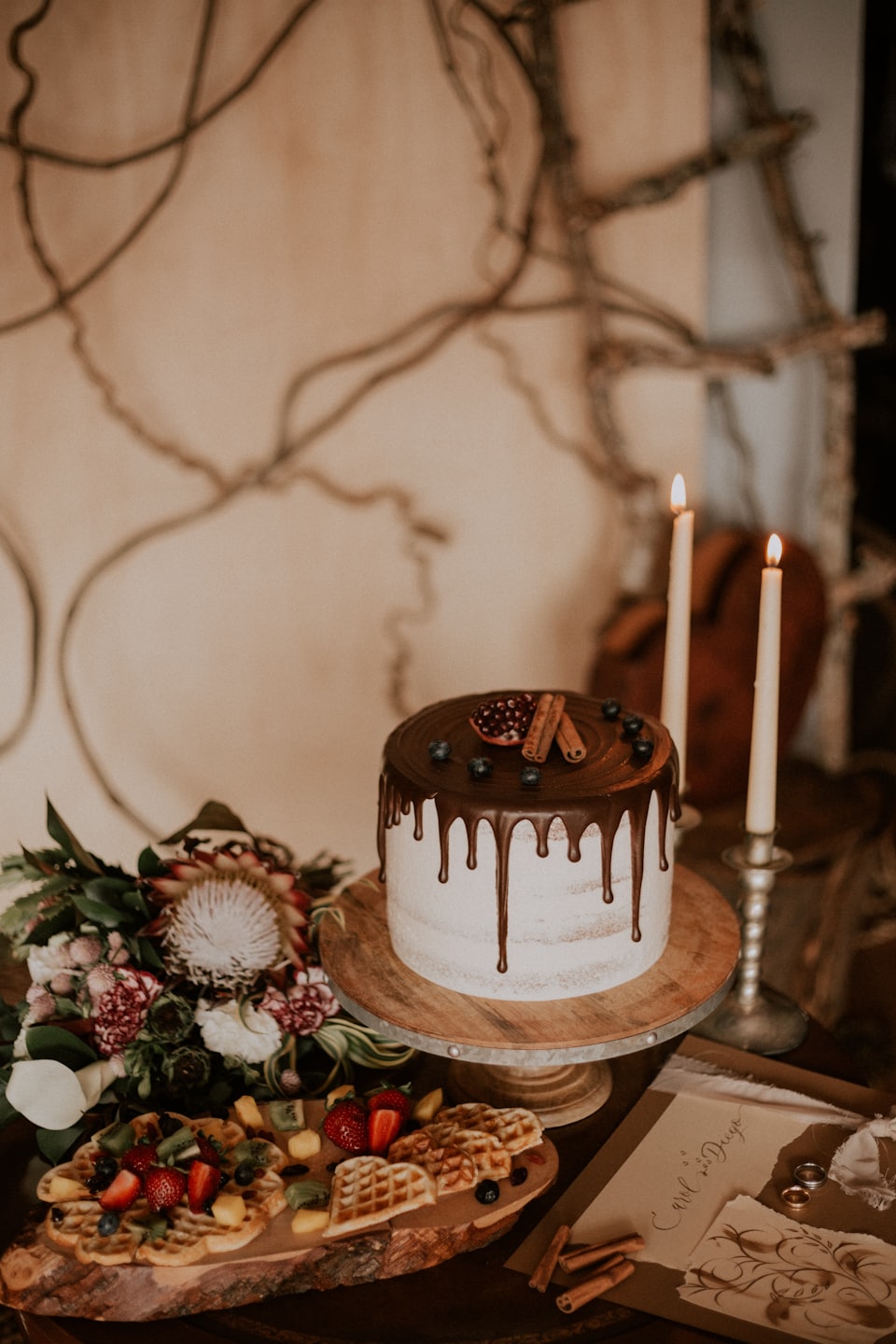 Dessert table with cake, waffles, and fruit for a celebration.