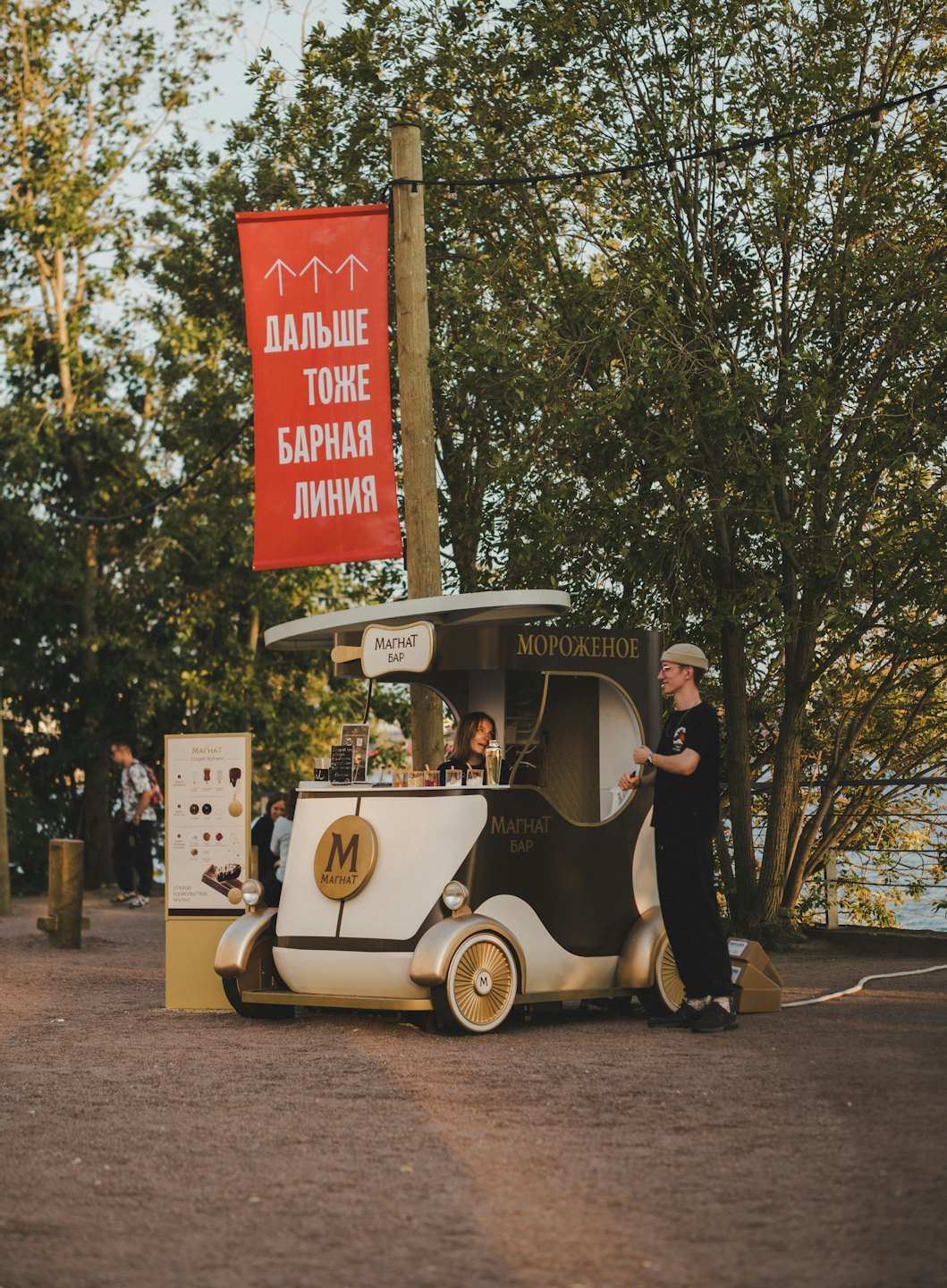 Employees serve customers from a vintage mobile ice cream cart.