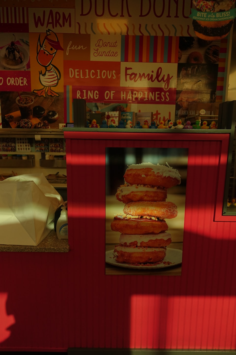 Donut shop wall decorated with mascot illustrations and product displays.