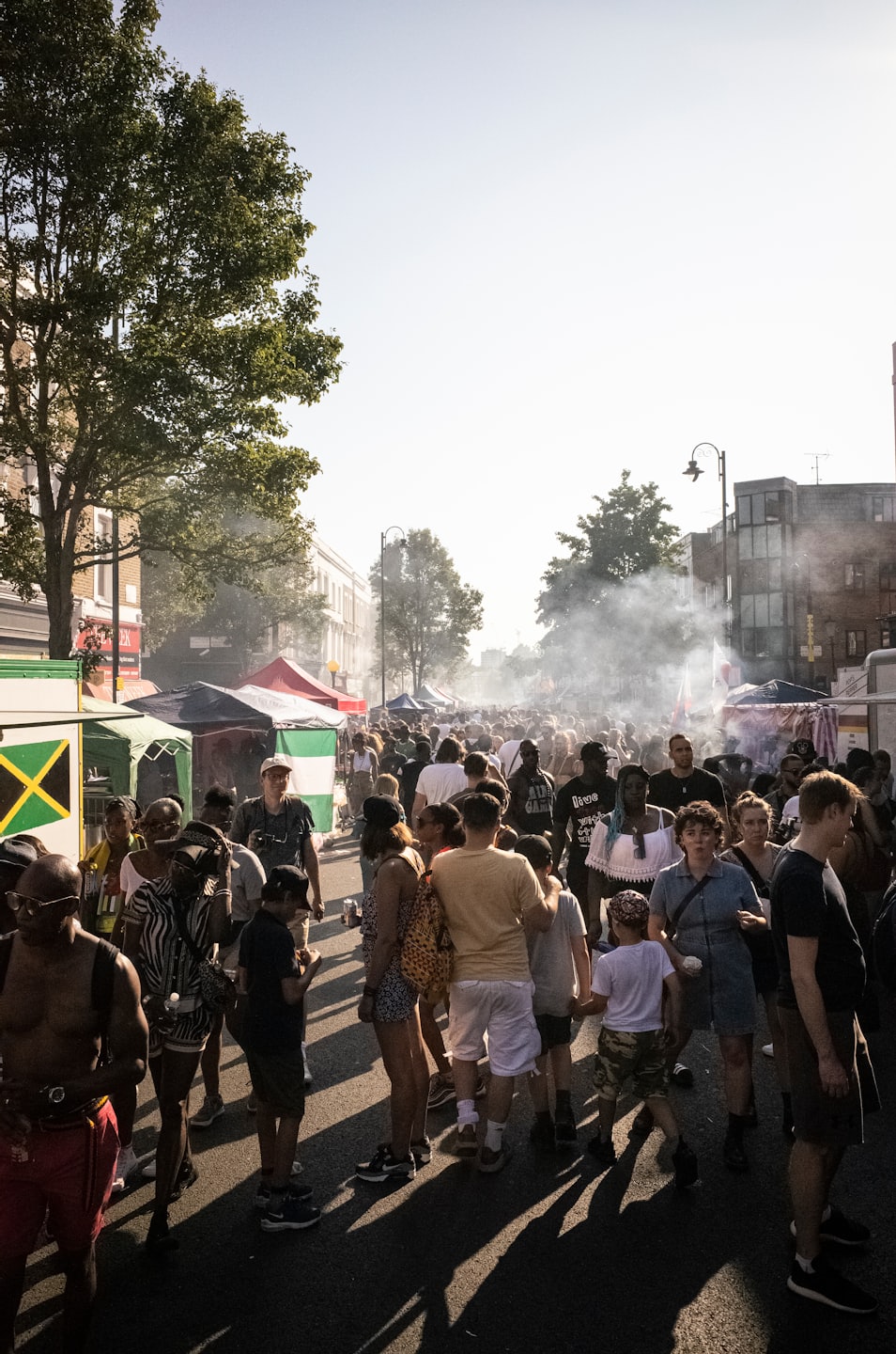 Crowds walk through market stalls at a busy outdoor festival.