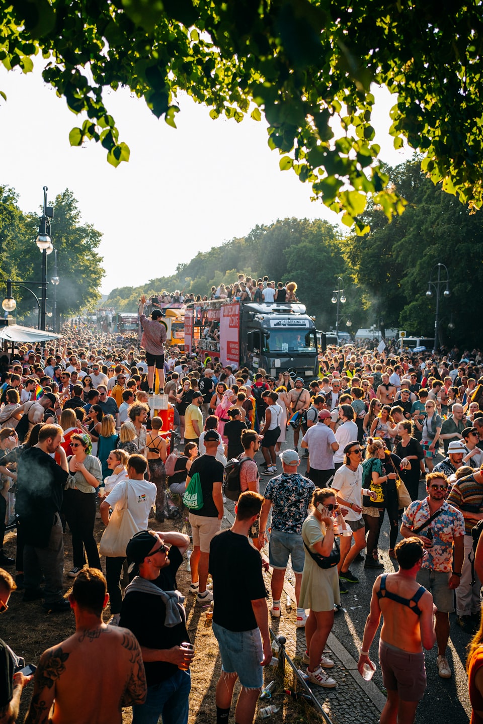 A crowd of people gathers around parade floats at a festival.